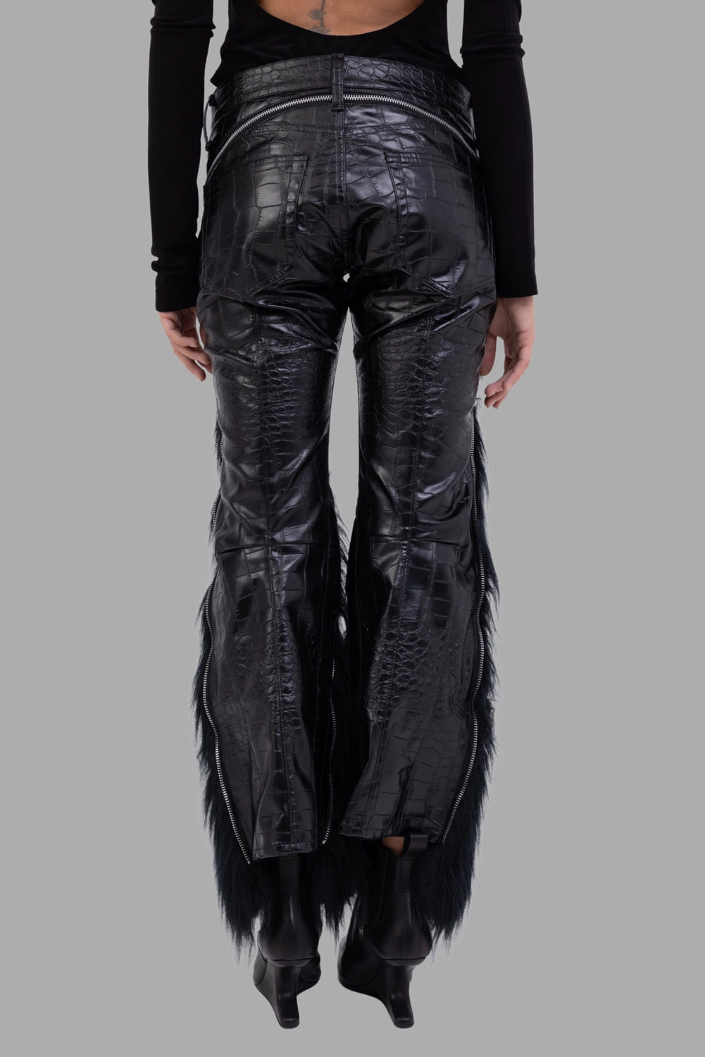 Junya Watanabe women trousers in black, back view, exposed waistband zip and shaped seams.