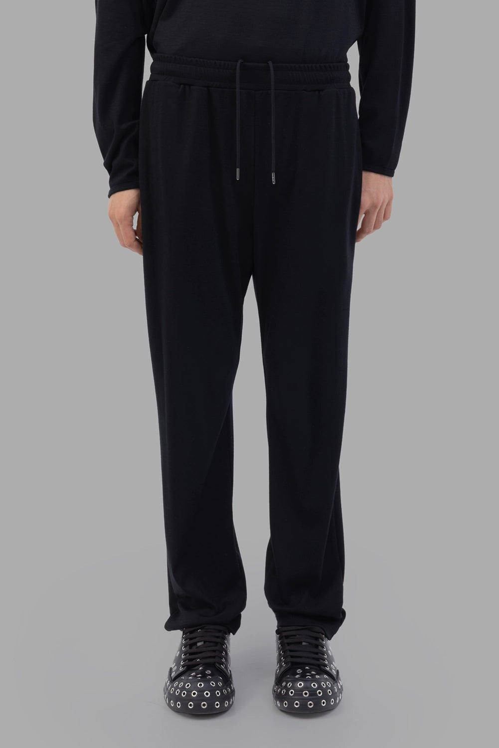 ATTACHMENT trousers in black, full-length on model, tapered leg and relaxed drape