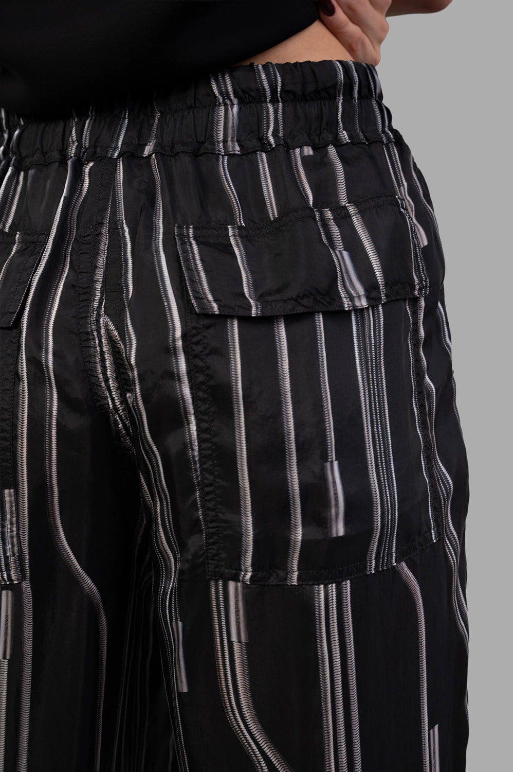 Rick Owens trousers in Black/Pearl, fabric close-up showing Wolffish stripe print and fluid cupro sheen.
