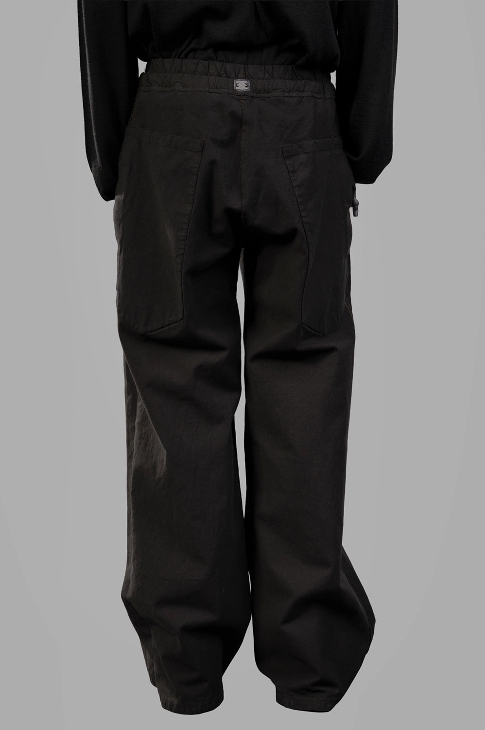 69 by Isaac Sellam trousers in noir, back view, large patch pockets and stapled tab at waistband