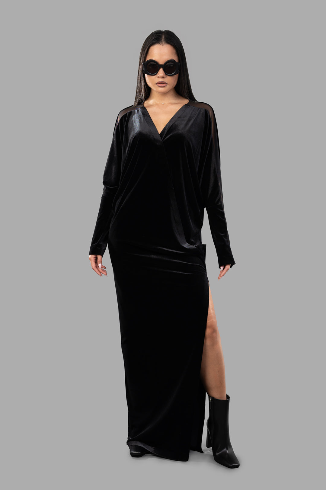 Norma Kamali Dolman Wrap Gown in black, front view with mesh inserts, long sleeves, v-neckline, and side slit.
