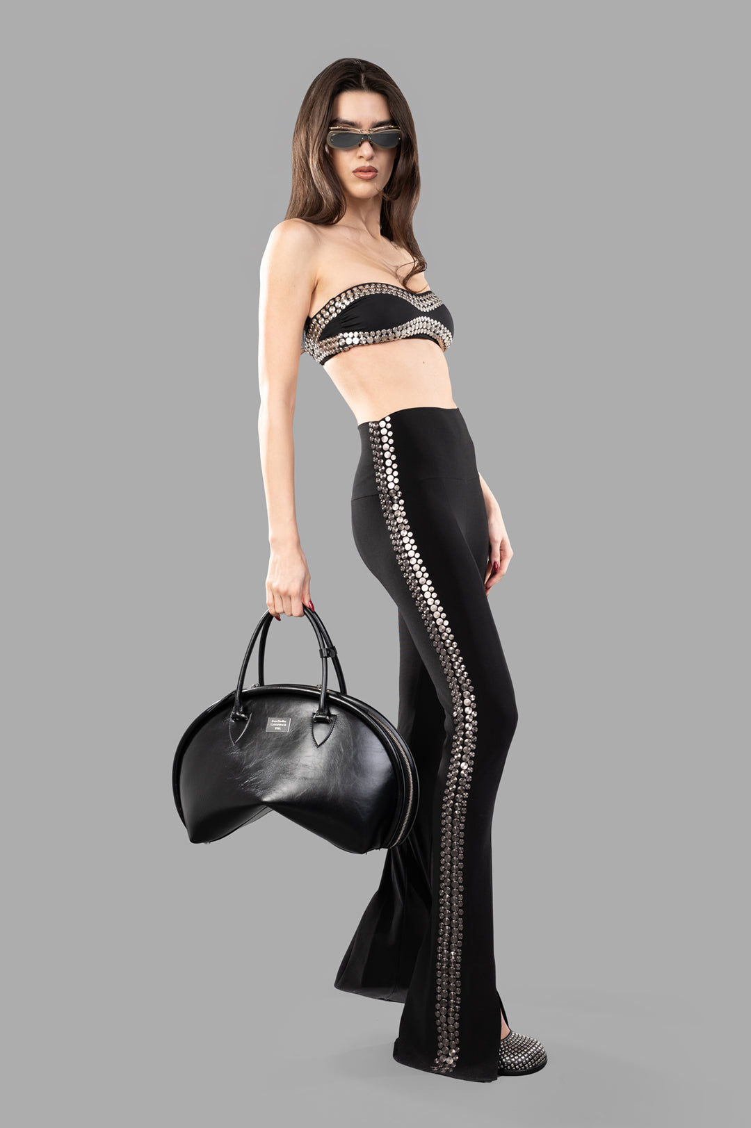 Norma Kamali Stud Spat Legging, side view on model, showcasing black high waist with silver stud detail and slight flare.