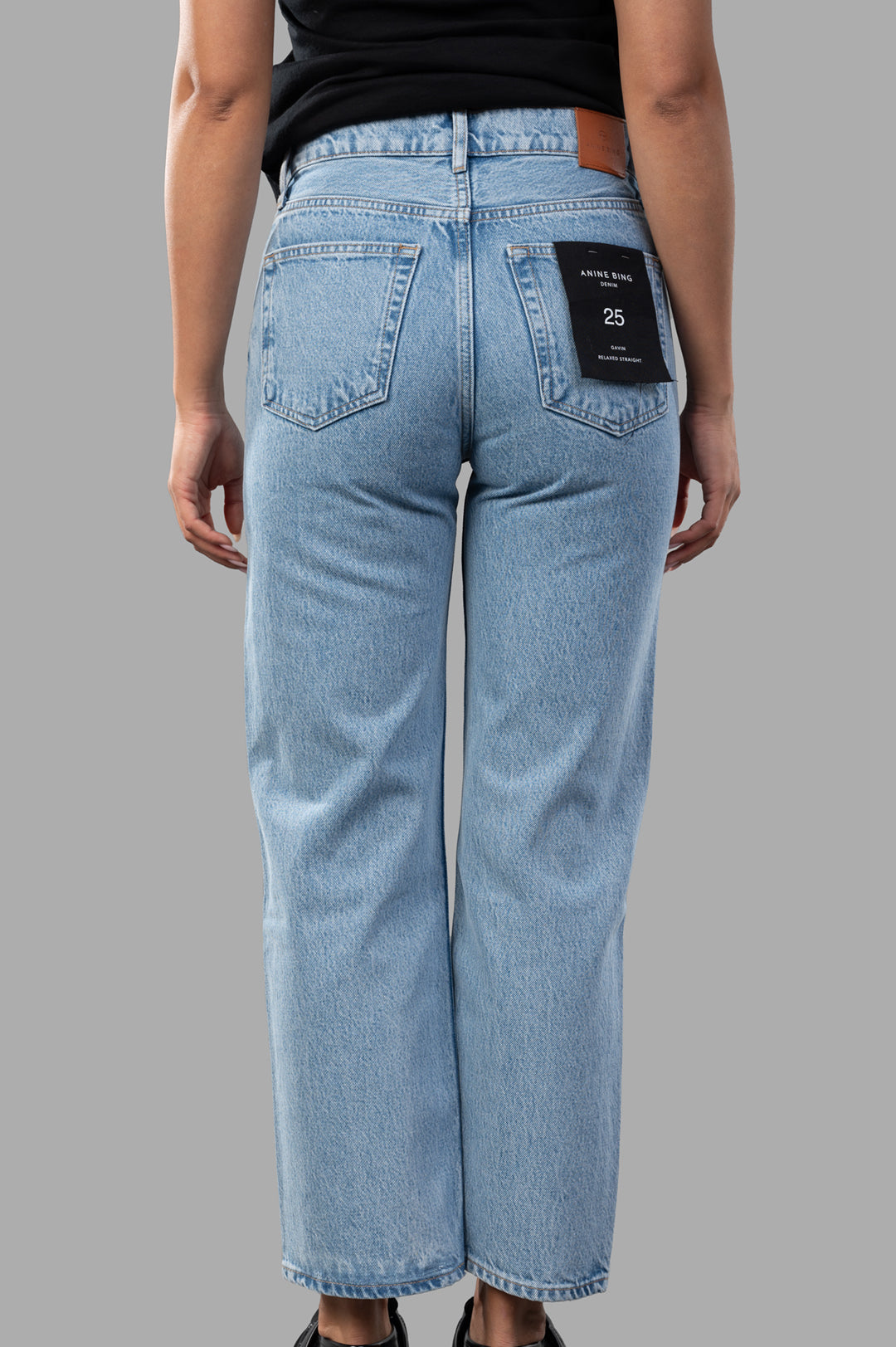 Anine Bing Gavin Jeans, a relaxed-straight fit in blue, showcasing the clean-edge hem and vintage-style back view.