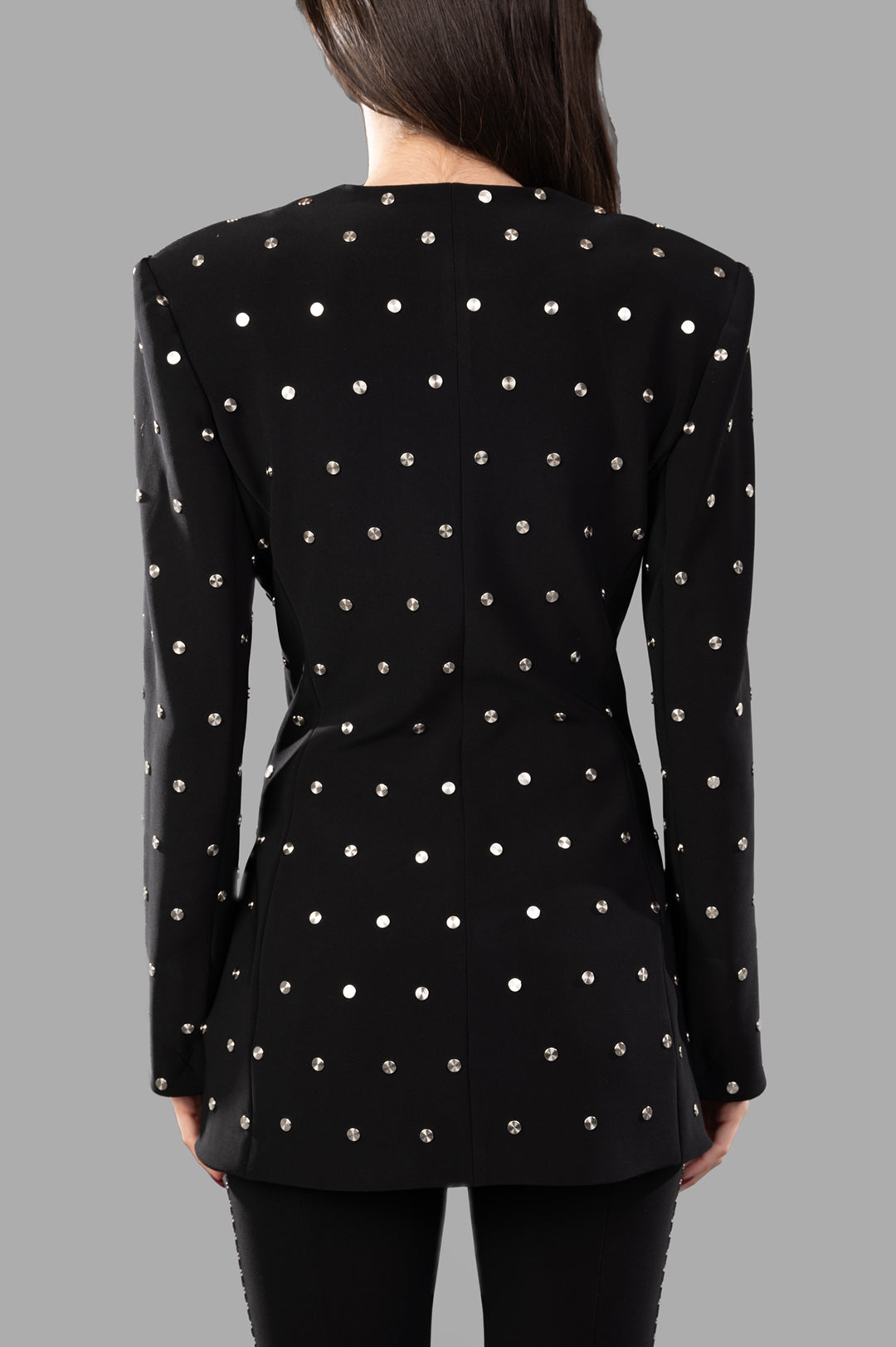 Norma Kamali Shoulder Pad Studded Jacket shown from the back, featuring studded embellishments on heavyweight stretch fabric.