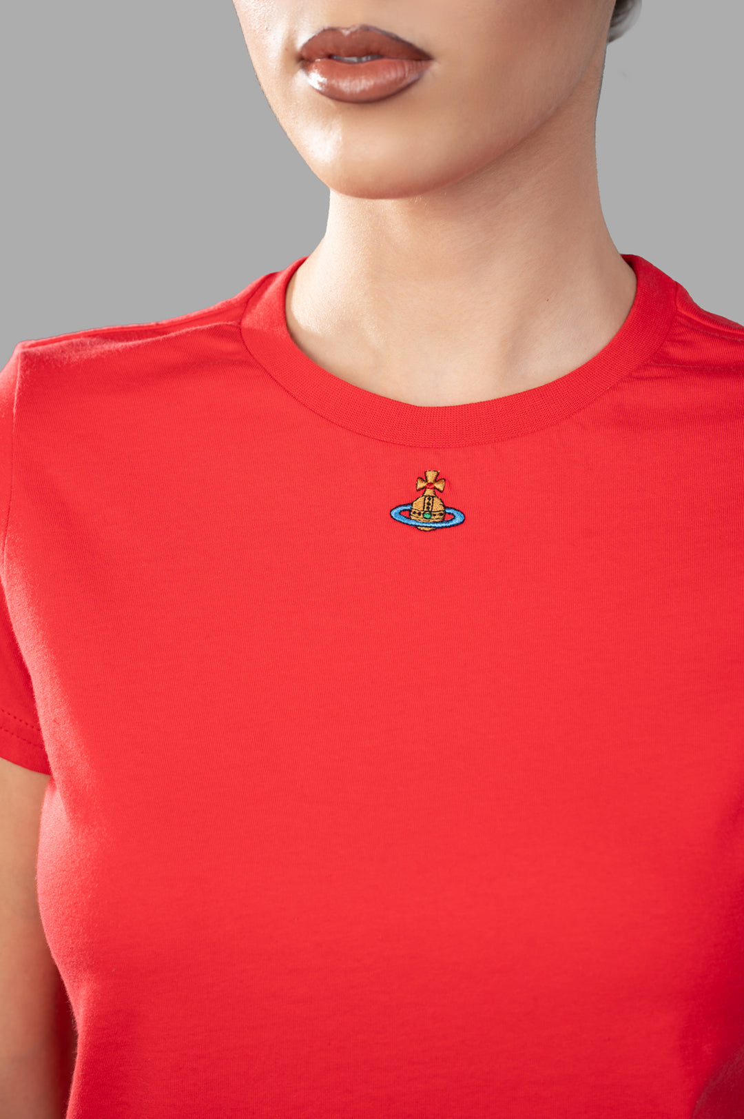 Vivienne Westwood Orb Logo T-shirt in Coral features a close-up of the embroidered logo on a model wearing a crewneck style.