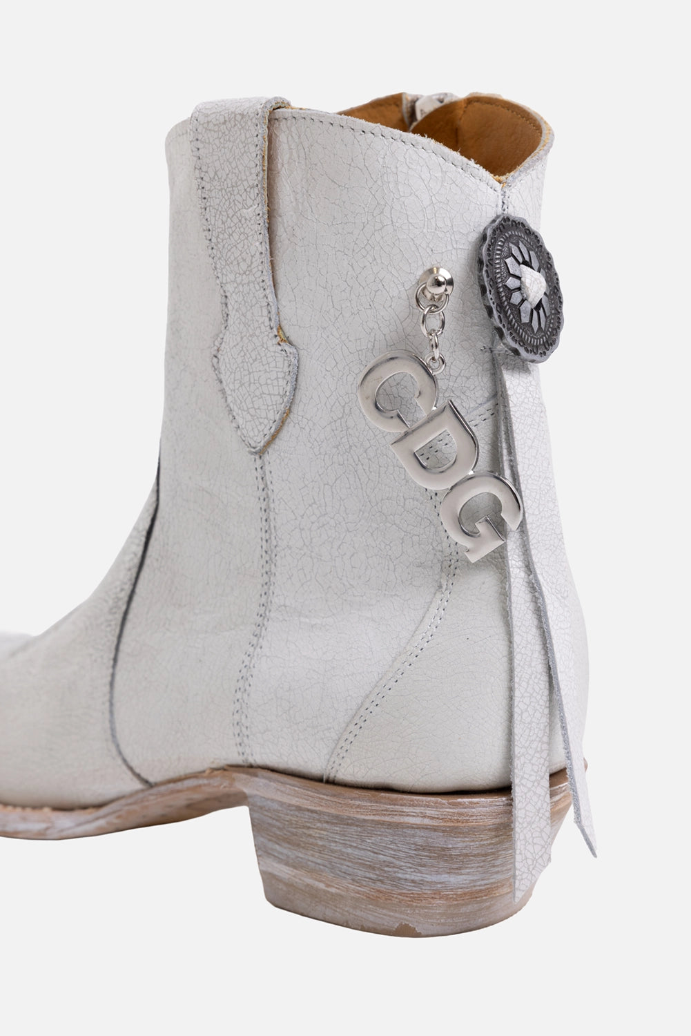 Comme des Garçons x Mexicana women's western ankle boots in white, hardware close-up with silver letter charms and concho